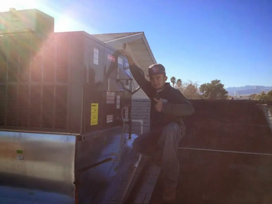 HVAC technician performing HVAC Inspection on a rooftop unit in Ada